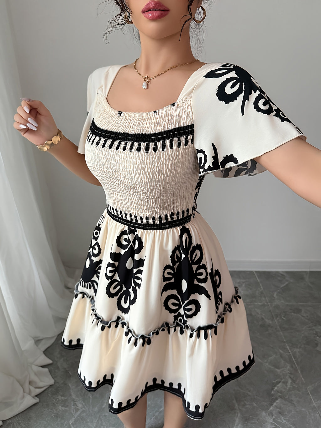 Vestido mini elegante com decote quadrado, estampas modernas, plissados, cintura cinchada para efeito slimming e bordas franzidas com bainha em linha A.