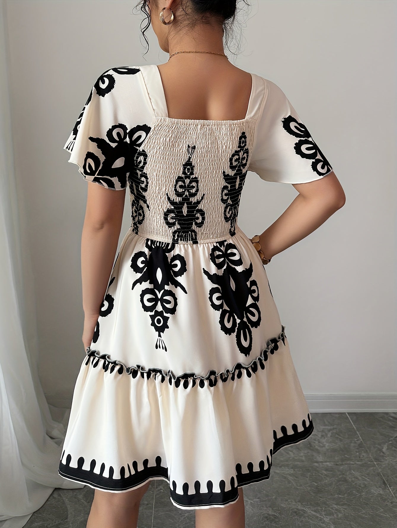 Vestido mini elegante com decote quadrado, estampas modernas, plissados, cintura cinchada para efeito slimming e bordas franzidas com bainha em linha A.