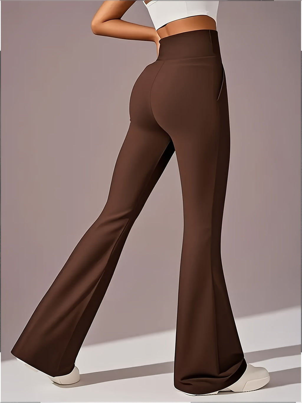 Um par de calças casuais de corte folgado para mulher, com pernas abertas, controlo abdominal e efeito lifting nas ancas, completas com bolsos. Fabricadas com tecido suave e agradável ao toque, oferecem uma sensação de conforto.