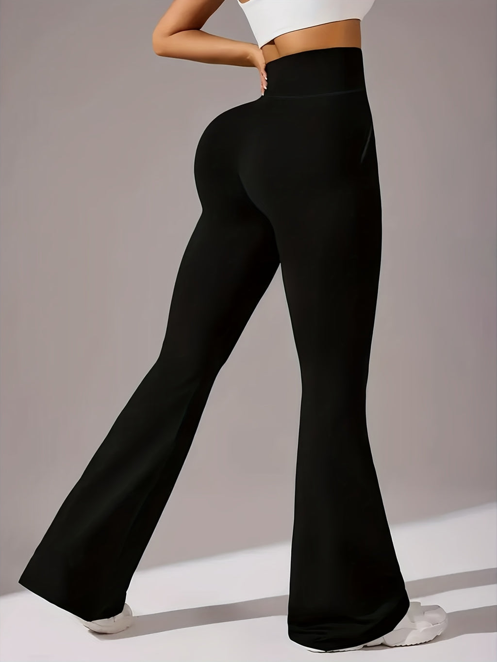 Um par de calças casuais de corte folgado para mulher, com pernas abertas, controlo abdominal e efeito lifting nas ancas, completas com bolsos. Fabricadas com tecido suave e agradável ao toque, oferecem uma sensação de conforto.