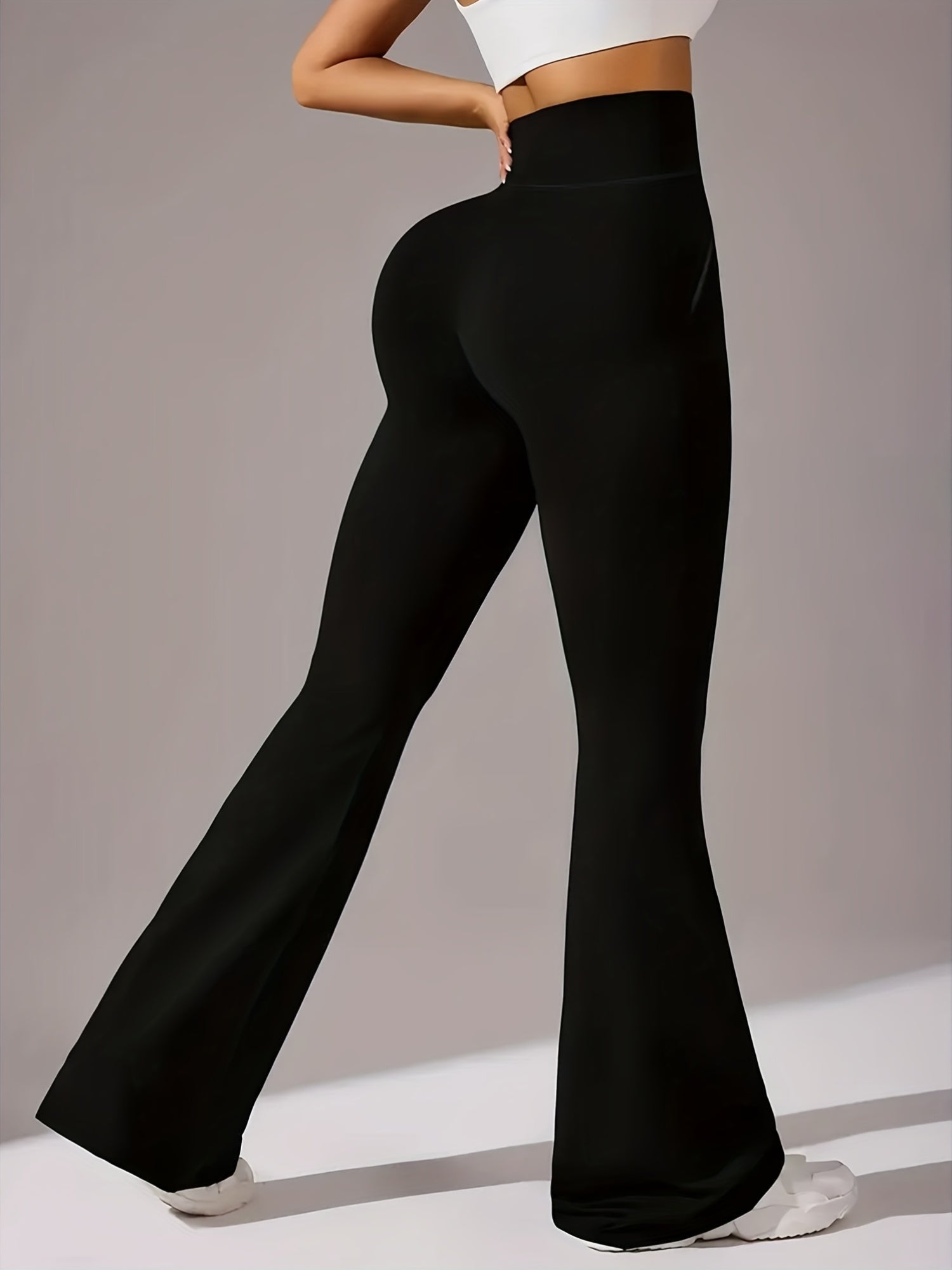 Um par de calças casuais de corte folgado para mulher, com pernas abertas, controlo abdominal e efeito lifting nas ancas, completas com bolsos. Fabricadas com tecido suave e agradável ao toque, oferecem uma sensação de conforto.