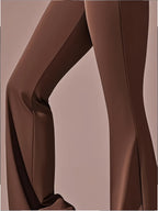 Um par de calças casuais de corte folgado para mulher, com pernas abertas, controlo abdominal e efeito lifting nas ancas, completas com bolsos. Fabricadas com tecido suave e agradável ao toque, oferecem uma sensação de conforto.